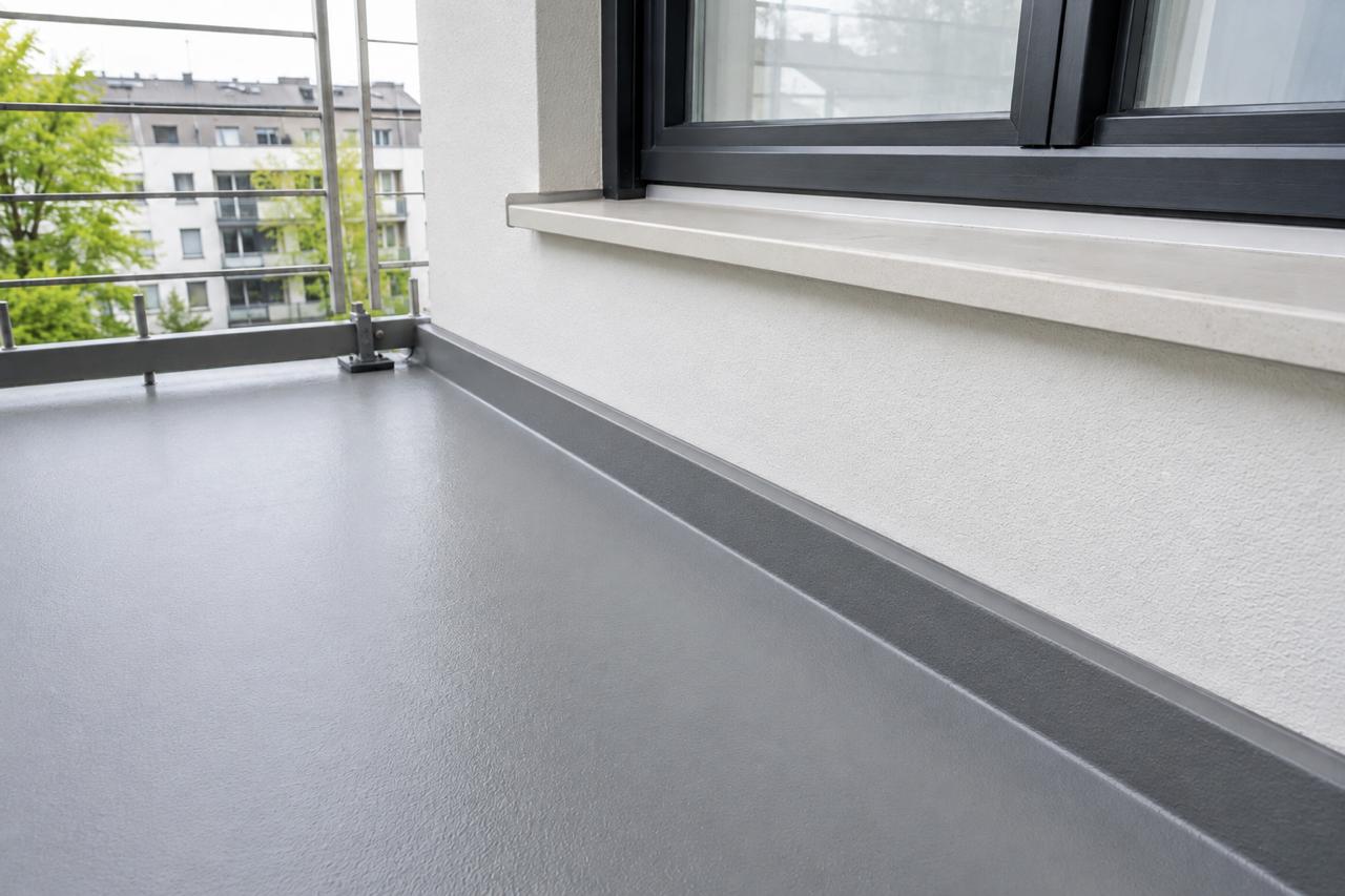 Balkon nach einer Sanierung: neue Beschichtung und sauber abgedichteter Wandanschluss