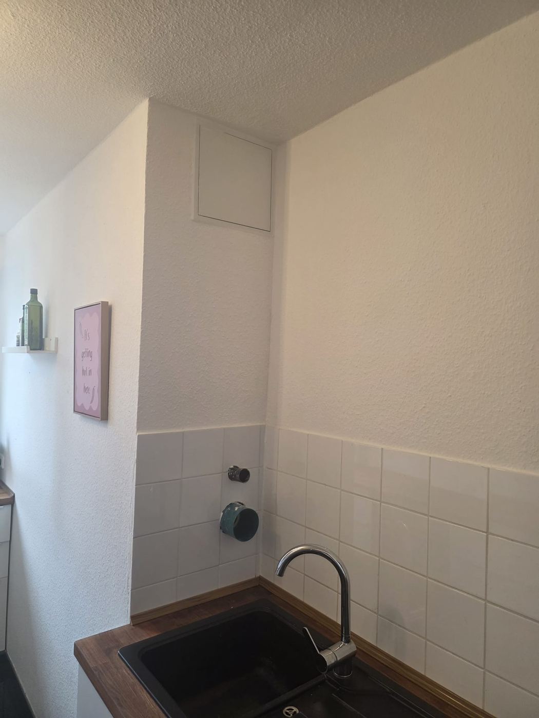 Geschlossener, verputzter und gefliester Wandbereich an derselben Stelle nach der Sanierung